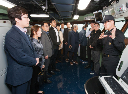 지난 15일 경남 진해에 위치한 해군 제8전투훈련단을 방문한 LIG넥스원 직원들이 대구함 헬기격납고에서 기념촬영을 하고 있다. LIG넥스원 제공